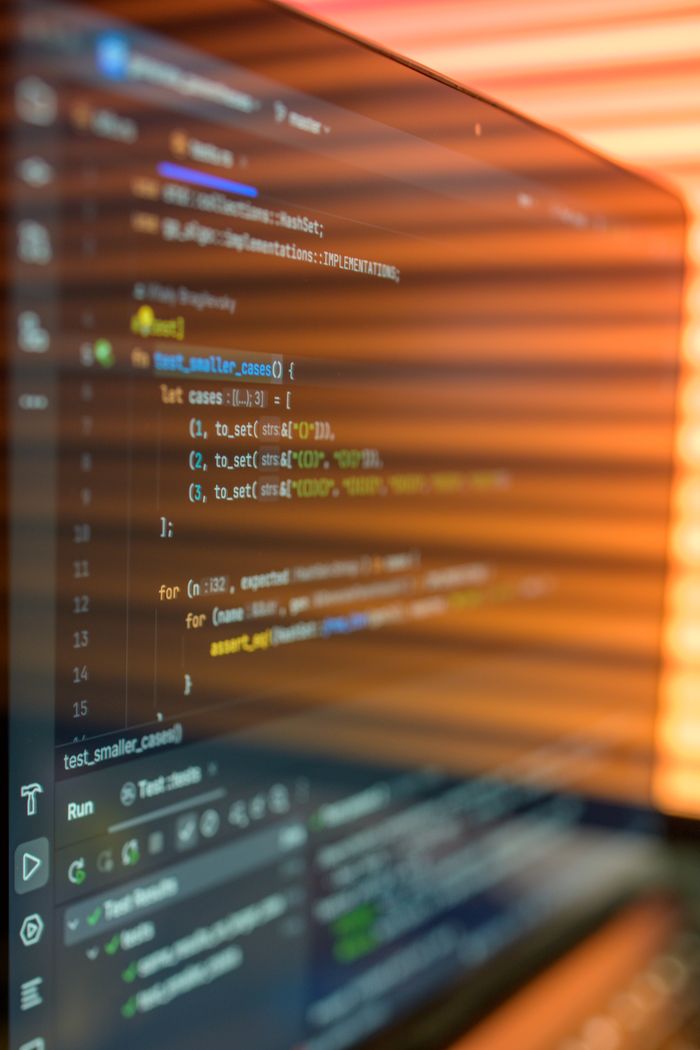 about-02 Close-up image of a computer screen displaying colorful programming code in a warm setting.