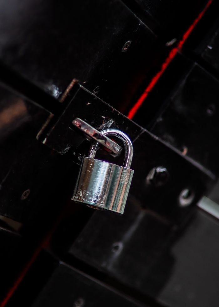 footer-01 Close-up view of a metal padlock securing a dark door latch, symbolizing safety and protection.